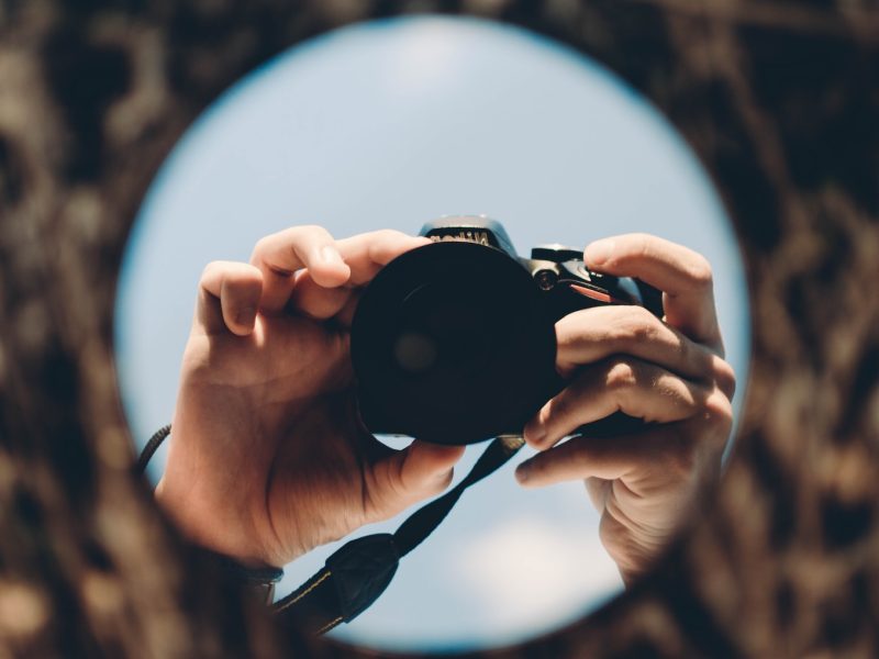 person holding black dslr camera